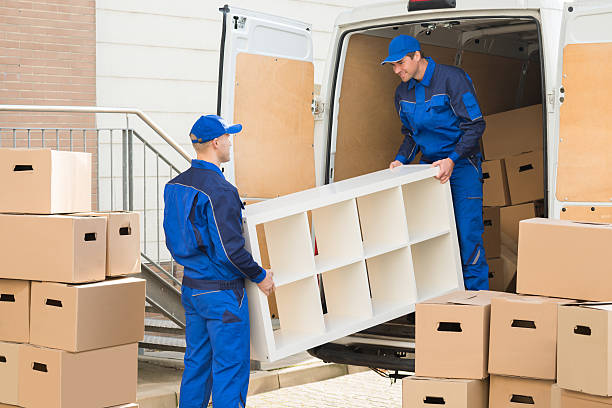 Young male movers unloading furniture and cardboard boxes from truck on street Marcelo's Movers | Affordable Moving from New York City to Georgia: How to Choose the Right Moving Company